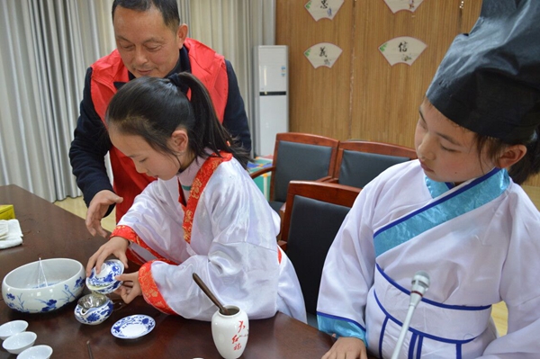 定远县职工小学的志愿者老师向孩子们传授茶道知识.jpg