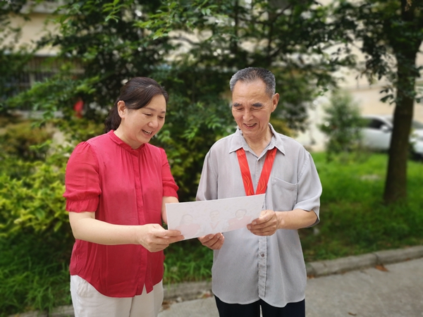 西大街社区党总支部书记上门为老党员方德新送纪念章颁发留影照片.jpg