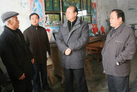 图为汪国才书记在村民周仁广家里